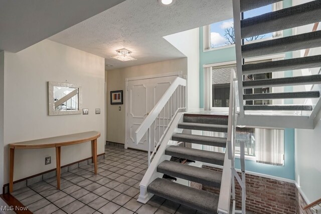613-3 Fairington Oval, Aurora, OH 44202 - stairway featuring baseboards and a textured ceiling
