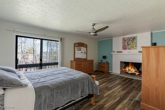 613-3 Fairington Oval, Aurora, OH 44202 - bedroom with dark wood-style flooring, a fireplace, access to exterior, a textured ceiling, and ceiling fan