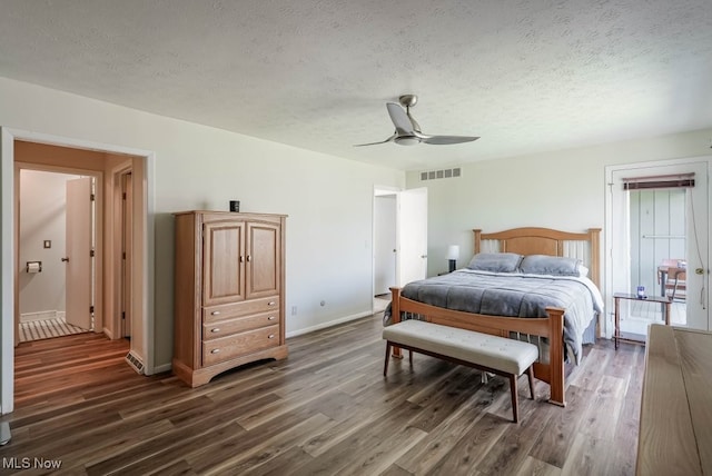 613-3 Fairington Oval, Aurora, OH 44202 - bedroom featuring a textured ceiling, dark wood-style floors, baseboards, and a ceiling fan