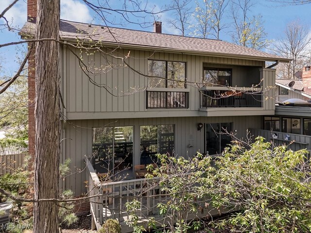 613-3 Fairington Oval, Aurora, OH 44202 - back of property with a chimney, a shingled roof, and a balcony