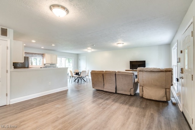 24560 Eldridge Blvd, Bedford Heights, OH 44146 - living area featuring light wood-type flooring, a textured ceiling, baseboards, and recessed lighting