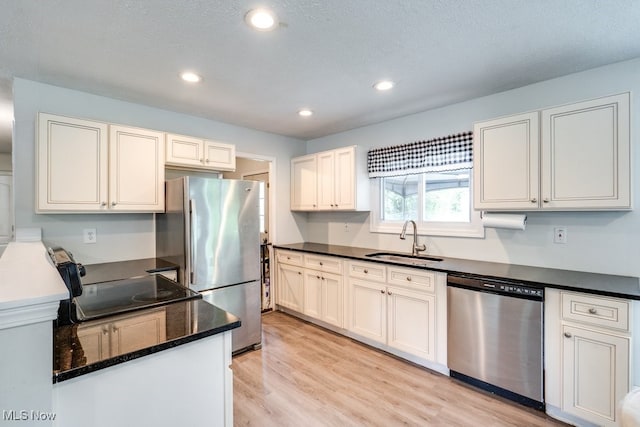 24560 Eldridge Blvd, Bedford Heights, OH 44146 - kitchen with stainless steel appliances, a sink, light wood-type flooring, recessed lighting, and dark stone counters