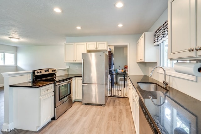24560 Eldridge Blvd, Bedford Heights, OH 44146 - kitchen with stainless steel appliances, a sink, a peninsula, light wood-style flooring, and recessed lighting