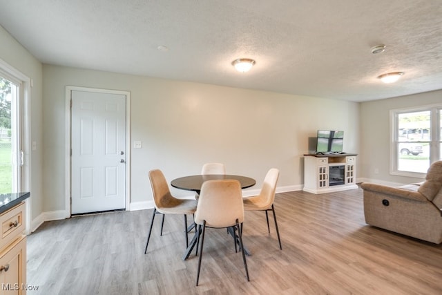 24560 Eldridge Blvd, Bedford Heights, OH 44146 - dining space featuring light wood-style flooring, a textured ceiling, and baseboards