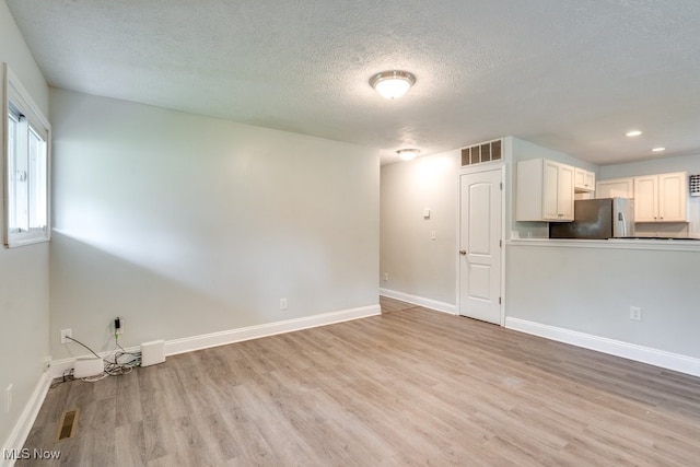 24560 Eldridge Blvd, Bedford Heights, OH 44146 - unfurnished living room with light wood-type flooring, a textured ceiling, baseboards, and recessed lighting