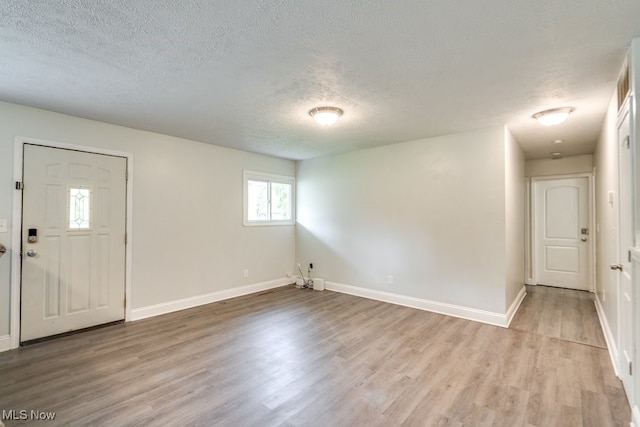 24560 Eldridge Blvd, Bedford Heights, OH 44146 - foyer entrance featuring a textured ceiling, light wood-style floors, and baseboards