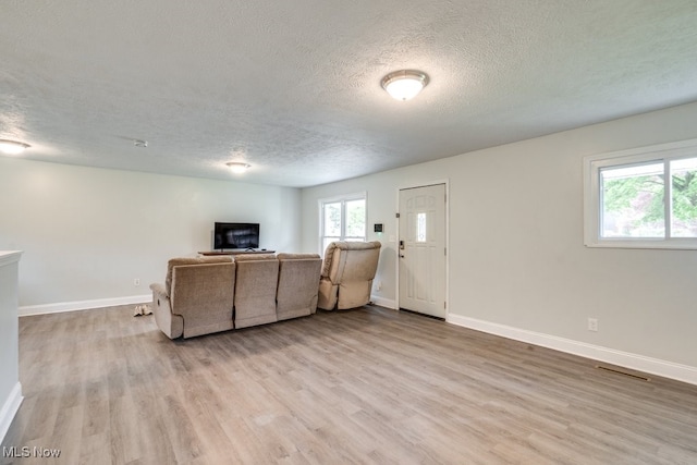 24560 Eldridge Blvd, Bedford Heights, OH 44146 - living room with a textured ceiling, light wood-type flooring, and baseboards