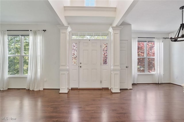 foyer with decorative columns, dark wood-style floors, plenty of natural light, and baseboards