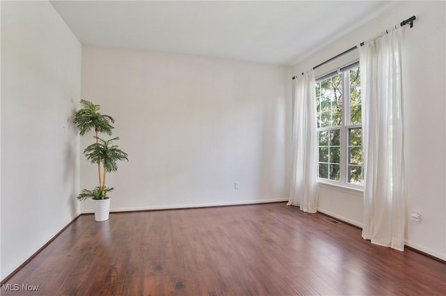 empty room with wood finished floors and baseboards