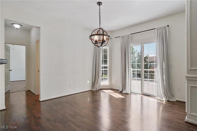 unfurnished dining area with a chandelier, dark wood-style flooring, and baseboards