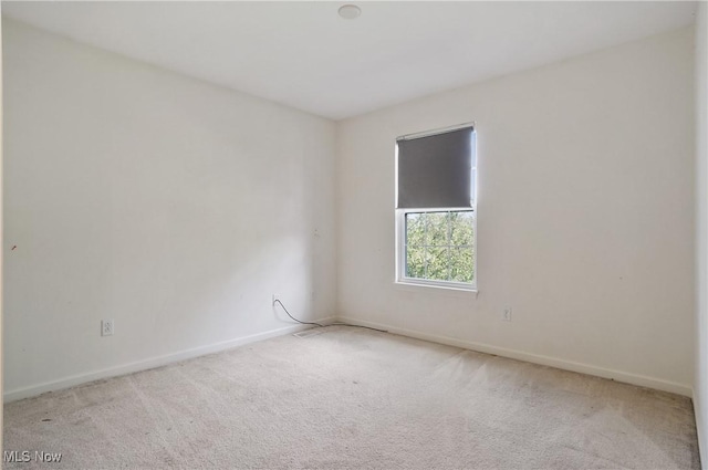 spare room featuring carpet floors and baseboards