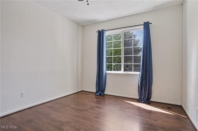 empty room featuring wood finished floors and baseboards