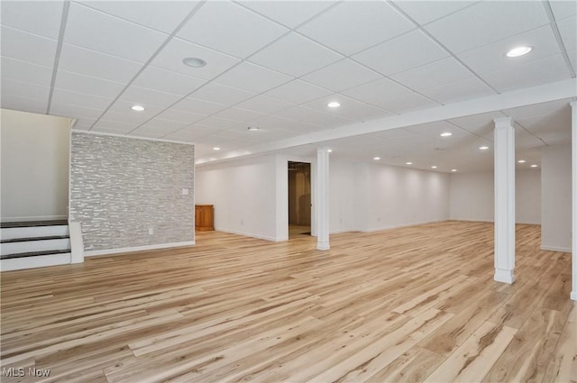 finished basement featuring light wood finished floors, stairway, a paneled ceiling, recessed lighting, and baseboards