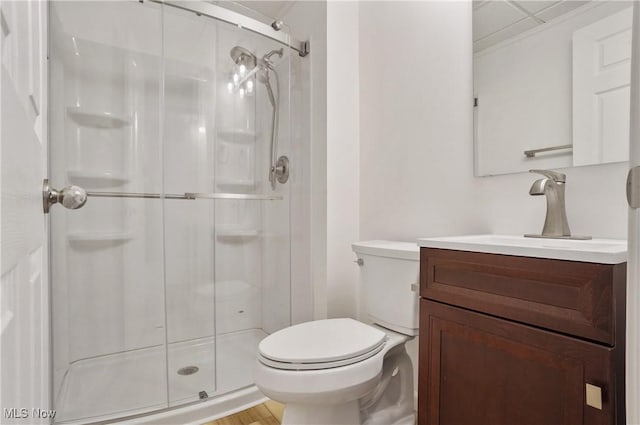 full bath featuring a stall shower, toilet, vanity, and wood finished floors