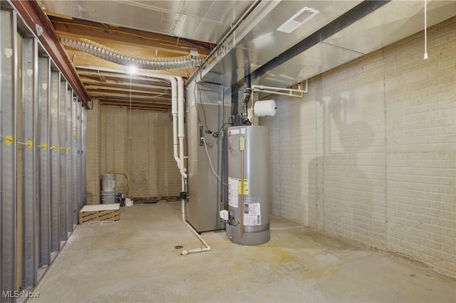 unfinished below grade area with gas water heater, brick wall, and heating unit