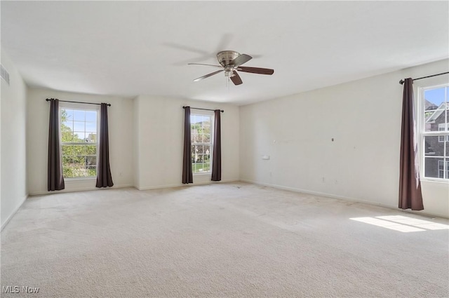 unfurnished room with plenty of natural light, ceiling fan, and light colored carpet