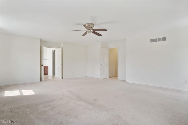 unfurnished room with ceiling fan, light colored carpet, and baseboards