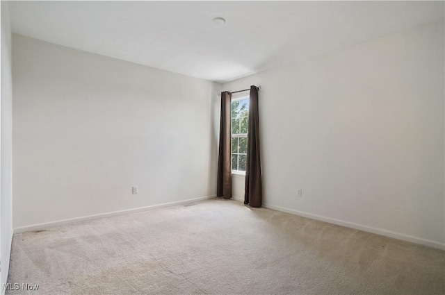carpeted spare room with baseboards