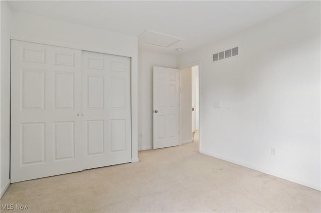 unfurnished bedroom featuring light colored carpet, a closet, and baseboards