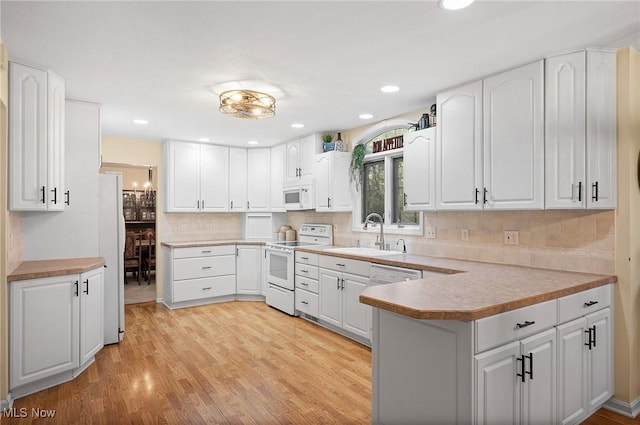 16538 S White Oaks Dr, Strongsville, OH 44136 - kitchen featuring white appliances, a sink, a peninsula, white cabinets, and recessed lighting