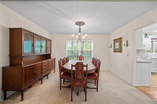 16538 S White Oaks Dr, Strongsville, OH 44136 - dining room featuring a chandelier, light carpet, a textured ceiling, and baseboards