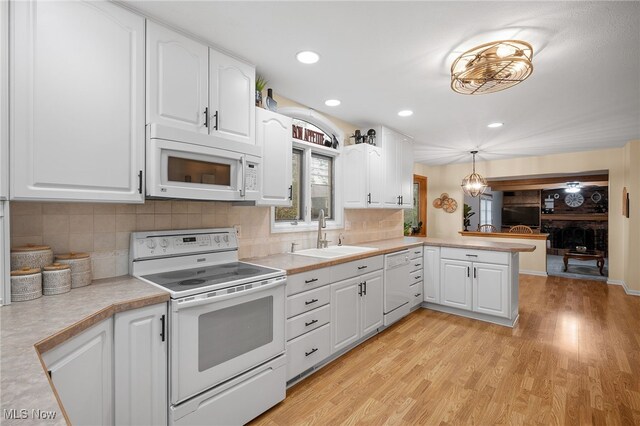 16538 S White Oaks Dr, Strongsville, OH 44136 - kitchen featuring white appliances, a sink, light countertops, a peninsula, and white cabinetry