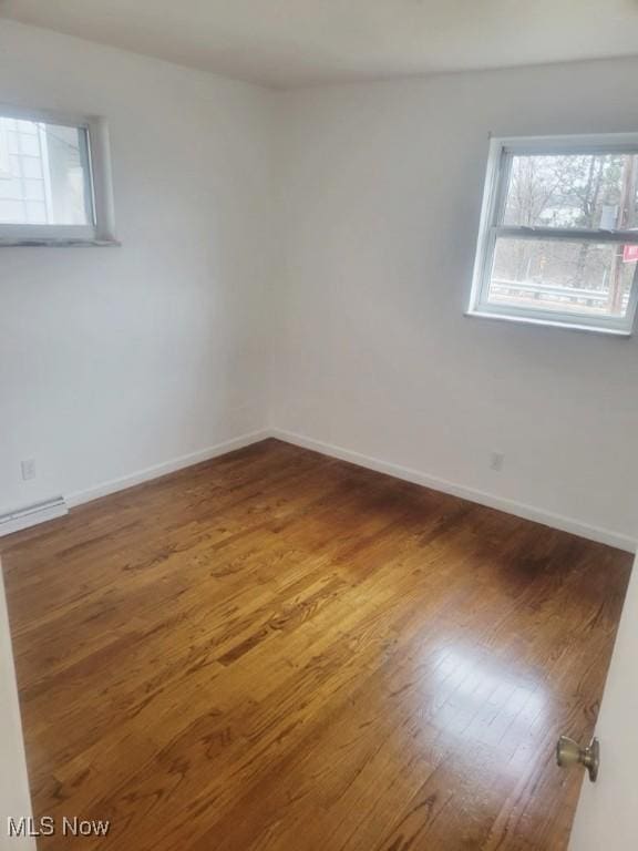 877 Gorge Blvd, Akron, OH 44310 - spare room with wood finished floors, baseboards, and a baseboard heating unit