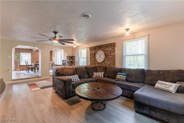 274 2nd St, Lake Milton, OH 44429 - living area featuring arched walkways, light wood-type flooring, a textured ceiling, ceiling fan, and baseboards
