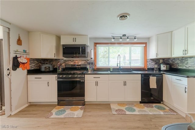 274 2nd St, Lake Milton, OH 44429 - kitchen featuring stainless steel appliances, a sink, dark countertops, light wood-style floors, and tasteful backsplash