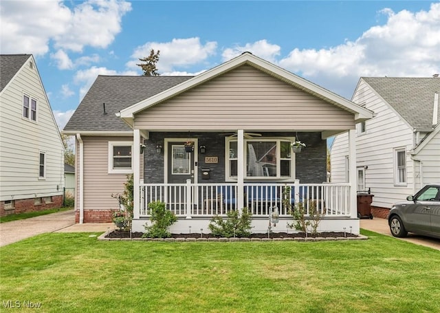 5610 Charles Ave, Parma, OH 44129 - view of front facade with covered porch, a front lawn, stone siding, and a shingled roof