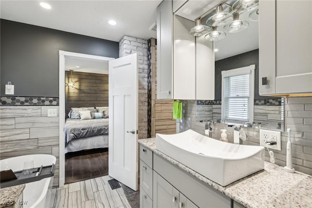 5610 Charles Ave, Parma, OH 44129 - bathroom with tile walls, a soaking tub, vanity, recessed lighting, and ensuite bathroom