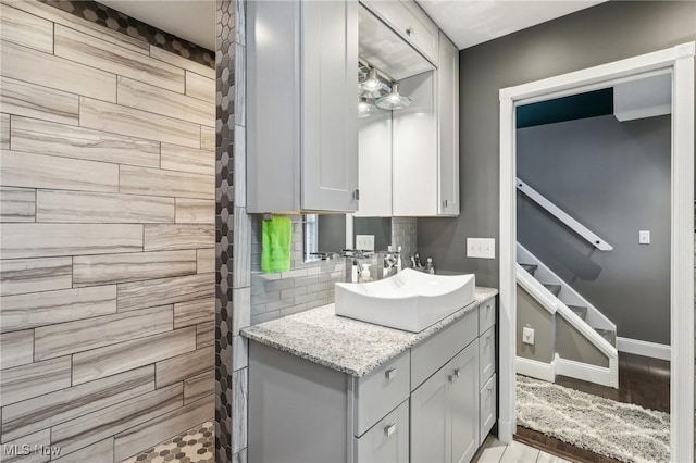 5610 Charles Ave, Parma, OH 44129 - bathroom featuring vanity, decorative backsplash, baseboards, and wood finished floors