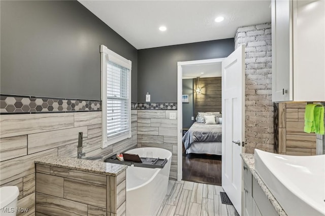 5610 Charles Ave, Parma, OH 44129 - full bath with tile walls, a soaking tub, recessed lighting, a wainscoted wall, and vanity