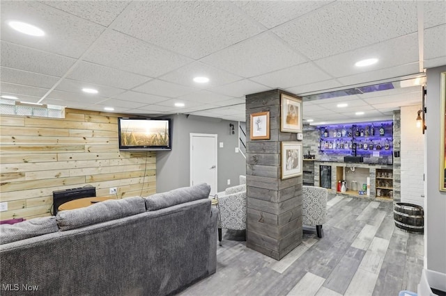 5610 Charles Ave, Parma, OH 44129 - living room with a paneled ceiling, wood finished floors, a bar, beverage cooler, and wooden walls