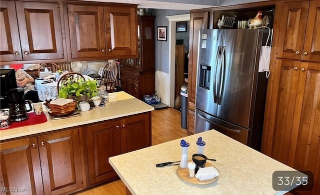 2681 Hooppole Ridge Rd E, Mcconnelsville, OH 43756 - kitchen with stainless steel refrigerator with ice dispenser, light countertops, light wood-style floors, and brown cabinets