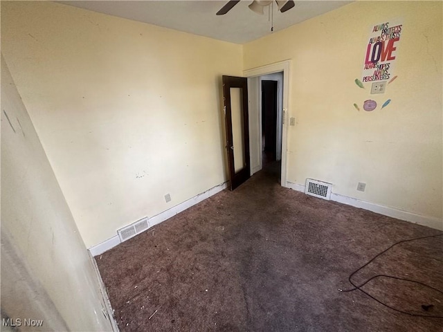 carpeted spare room featuring ceiling fan and baseboards