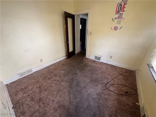 carpeted empty room featuring baseboards