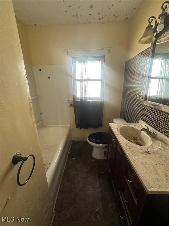 full bathroom with healthy amount of natural light, vanity, toilet, and tasteful backsplash