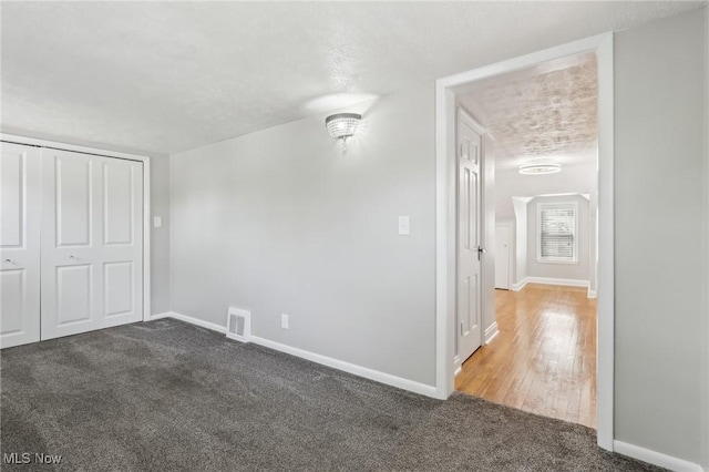 unfurnished bedroom featuring carpet, baseboards, and a closet