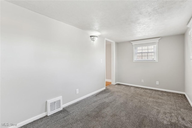 spare room featuring a textured ceiling, baseboards, and carpet floors