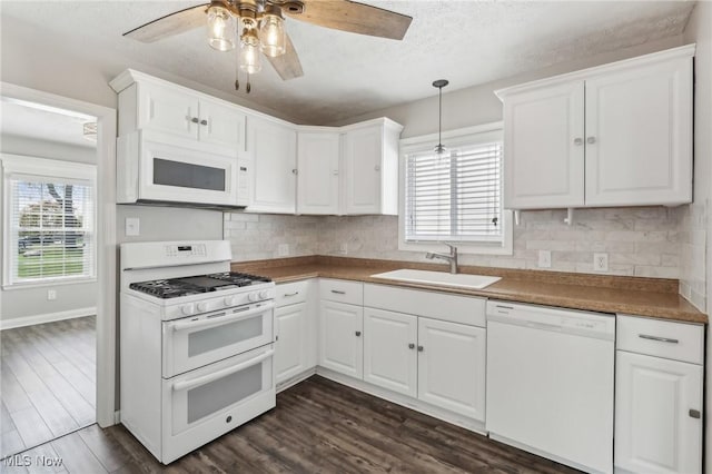 kitchen with white appliances, a sink, ceiling fan, plenty of natural light, and a textured ceiling
