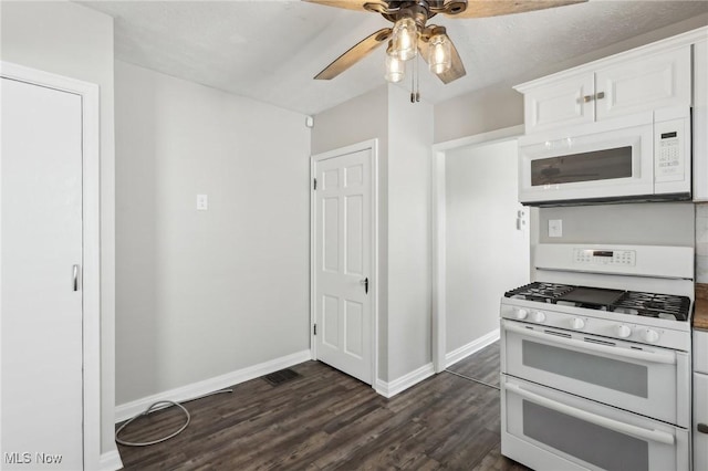 kitchen with white appliances, ceiling fan, dark wood finished floors, baseboards, and white cabinets