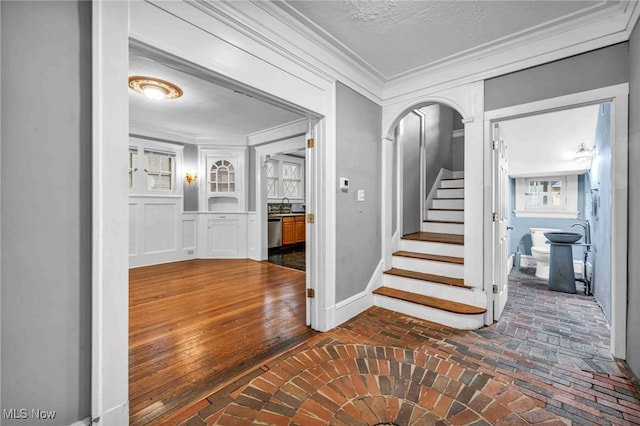 103 N Portage Path, Akron, OH 44303 - hallway featuring brick floors, crown molding, stairway, baseboards, and arched walkways