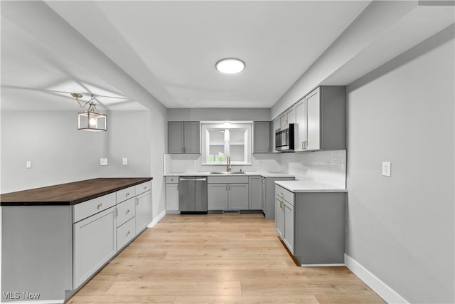 2394 Reimer Rd, Wadsworth, OH 44281 - kitchen featuring appliances with stainless steel finishes, gray cabinets, light wood finished floors, and a peninsula