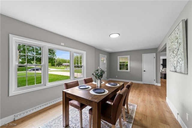 2394 Reimer Rd, Wadsworth, OH 44281 - dining room featuring a baseboard heating unit, light wood-style flooring, and baseboards
