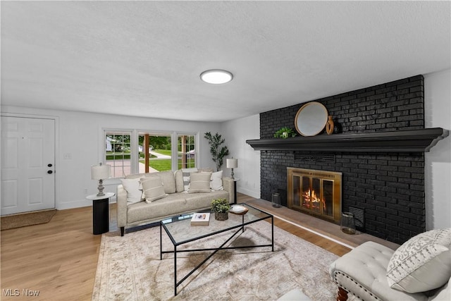 2394 Reimer Rd, Wadsworth, OH 44281 - living area with a brick fireplace, wood finished floors, baseboards, and a textured ceiling