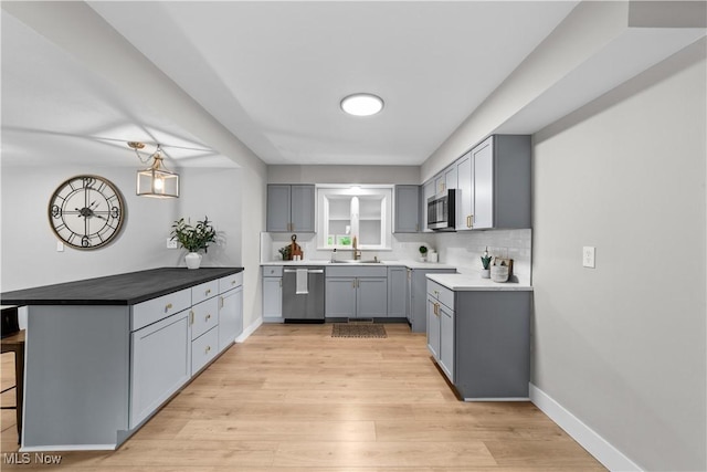 2394 Reimer Rd, Wadsworth, OH 44281 - kitchen featuring stainless steel appliances, light wood-style flooring, gray cabinetry, and a peninsula