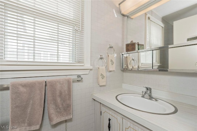 bathroom with tasteful backsplash, vanity, and tile walls