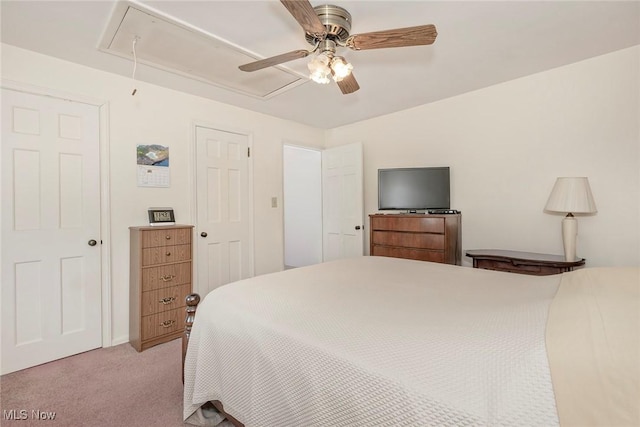 carpeted bedroom featuring attic access and ceiling fan