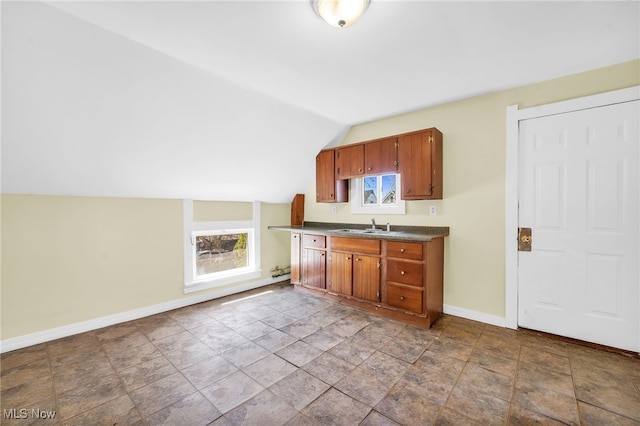 2142 W 95th St, Cleveland, OH 44102 - kitchen featuring baseboards, dark countertops, a sink, lofted ceiling, and brown cabinetry